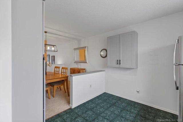 93 Cosey Beach Ave Apt 5, East Haven, CT 06512 - kitchen featuring freestanding refrigerator, dark flooring, and a textured ceiling