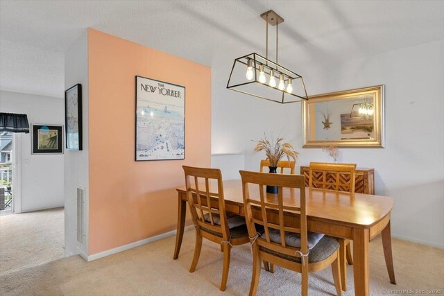 93 Cosey Beach Ave Apt 5, East Haven, CT 06512 - carpeted dining room featuring a chandelier and baseboards