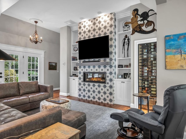 14 Ely Ln, Killingworth, CT 06419 - living room featuring wood finished floors, built in features, a chandelier, and a tiled fireplace