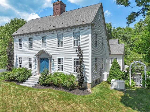 14 Ely Ln, Killingworth, CT 06419 - view of front of house with a chimney, roof with shingles, and a front lawn