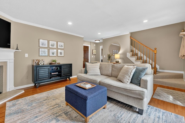 215 Georgetown Dr, Glastonbury, CT 06033 - living area with wood finished floors, a fireplace with raised hearth, stairs, recessed lighting, and crown molding