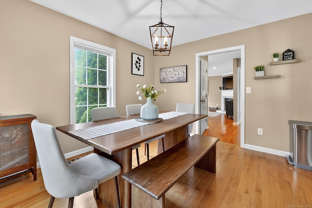 215 Georgetown Dr, Glastonbury, CT 06033 - dining room featuring a chandelier, light wood-style floors, and a fireplace