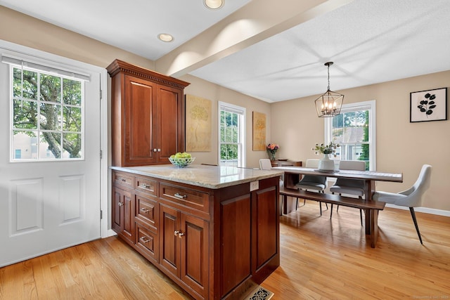 215 Georgetown Dr, Glastonbury, CT 06033 - kitchen with light wood-style flooring, hanging light fixtures, a chandelier, light stone countertops, and brown cabinetry