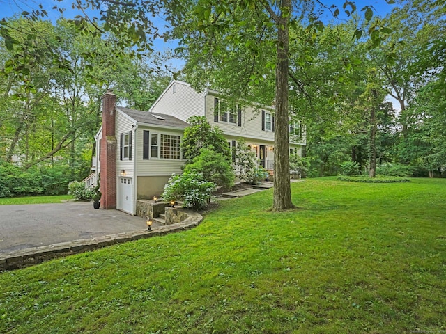 119 Deforest Rd, Wilton, CT 06897 - view of side of property with a chimney, asphalt driveway, a garage, and a yard