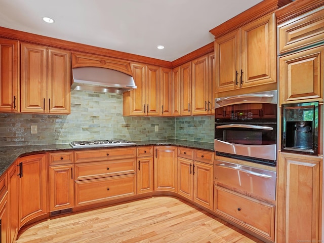 119 Deforest Rd, Wilton, CT 06897 - kitchen with a warming drawer, appliances with stainless steel finishes, dark stone counters, light wood-style floors, and brown cabinetry