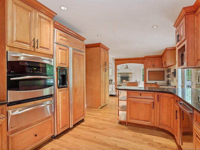 119 Deforest Rd, Wilton, CT 06897 - kitchen featuring a warming drawer, appliances with stainless steel finishes, light wood-style flooring, recessed lighting, and a warm lit fireplace