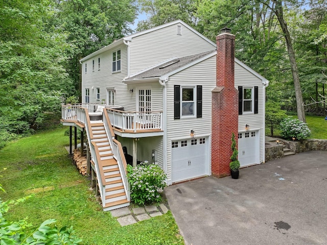 119 Deforest Rd, Wilton, CT 06897 - back of house with a chimney, asphalt driveway, stairway, a garage, and a deck