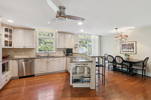 172 Mimosa Cir, Ridgefield, CT 06877 - kitchen with stainless steel dishwasher, a peninsula, healthy amount of natural light, a breakfast bar area, and recessed lighting