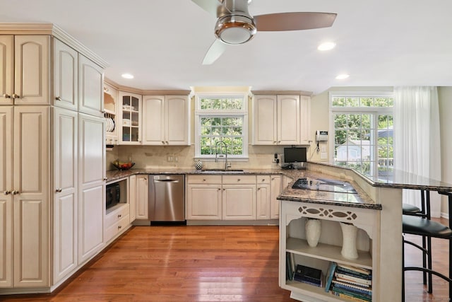 172 Mimosa Cir, Ridgefield, CT 06877 - kitchen with stainless steel dishwasher, a kitchen bar, a peninsula, dark stone counters, and recessed lighting