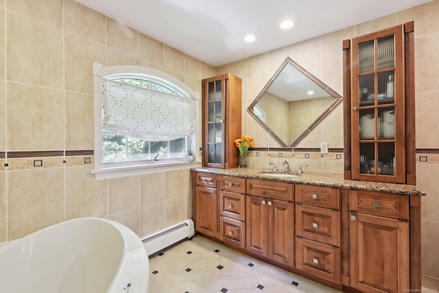 172 Mimosa Cir, Ridgefield, CT 06877 - full bath featuring a baseboard heating unit, tile walls, vanity, a tub to relax in, and tile patterned floors