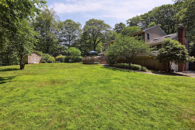 172 Mimosa Cir, Ridgefield, CT 06877 - view of grassy yard with a wooden deck, a storage shed, and a garage