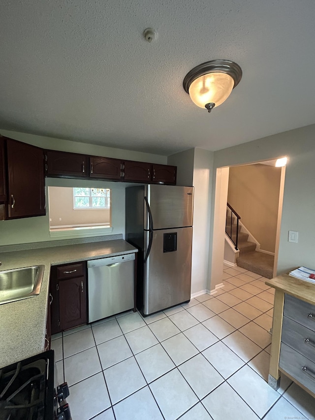 58 E Gate Ln Unit 58, Hamden, CT 06514 - kitchen with appliances with stainless steel finishes, dark brown cabinetry, light countertops, light tile patterned floors, and a textured ceiling