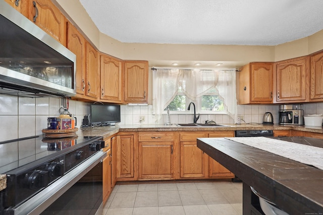 229 Hauser St, Waterbury, CT 06704 - kitchen with stainless steel microwave, range with electric stovetop, tasteful backsplash, light tile patterned flooring, and brown cabinets