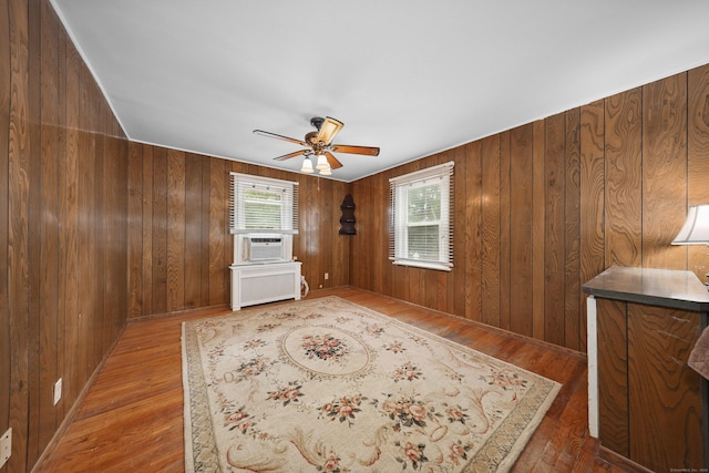 229 Hauser St, Waterbury, CT 06704 - empty room with wood finished floors, a ceiling fan, wood walls, cooling unit, and radiator heating unit
