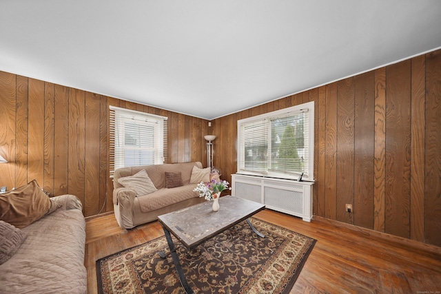 229 Hauser St, Waterbury, CT 06704 - living room featuring radiator heating unit, plenty of natural light, wood walls, and wood finished floors