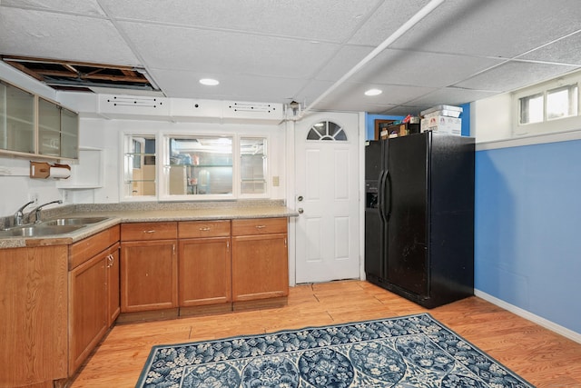 229 Hauser St, Waterbury, CT 06704 - kitchen with black refrigerator with ice dispenser, light wood-type flooring, brown cabinets, glass insert cabinets, and light countertops