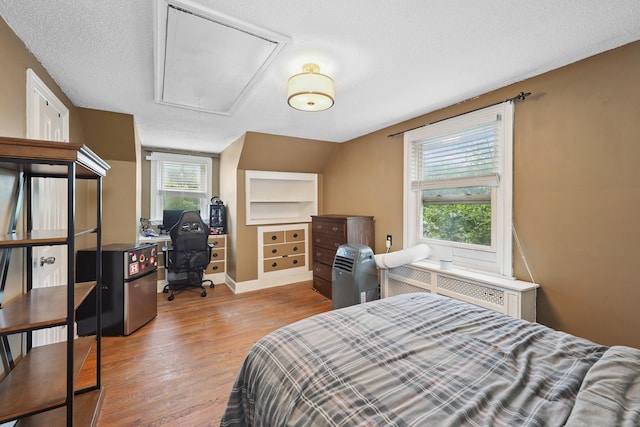 229 Hauser St, Waterbury, CT 06704 - bedroom featuring attic access, radiator, wood finished floors, a textured ceiling, and an office area