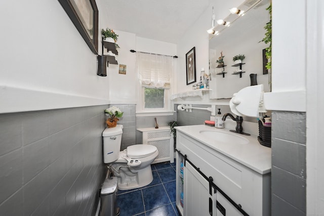229 Hauser St, Waterbury, CT 06704 - bathroom with tile patterned floors, tile walls, a wainscoted wall, vanity, and radiator heating unit
