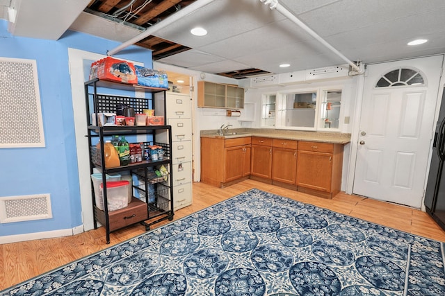 229 Hauser St, Waterbury, CT 06704 - kitchen featuring brown cabinetry, light wood-style floors, light countertops, recessed lighting, and glass insert cabinets