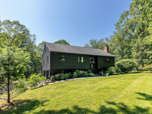 40 Revere Rd, Washington, CT 06793 - view of front facade with a chimney, a front yard, and roof with shingles