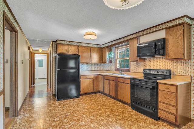 18 Saint Joseph Ct, Groton, CT 06340 - kitchen featuring black appliances, light countertops, brown cabinetry, a textured ceiling, and light flooring
