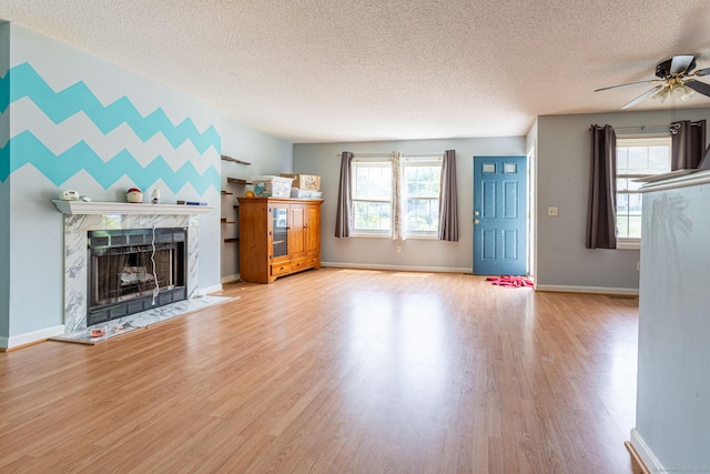 286 Laura Blvd Unit 286, Norwich, CT 06360 - unfurnished living room featuring a textured ceiling, a ceiling fan, wood finished floors, a high end fireplace, and healthy amount of natural light