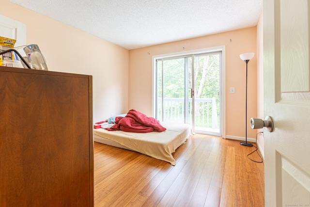 286 Laura Blvd Unit 286, Norwich, CT 06360 - bedroom featuring access to outside, light wood-style flooring, and a textured ceiling