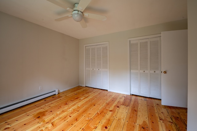 30 Streamview Cir, Guilford, CT 06437 - unfurnished bedroom with a baseboard heating unit, two closets, light wood-style flooring, and ceiling fan
