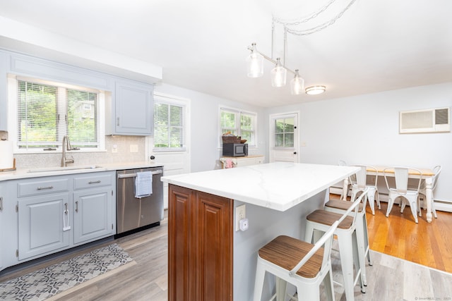 47 Dogwood Ln, Meriden, CT 06450 - kitchen featuring stainless steel dishwasher, a wall unit AC, light wood-style floors, a breakfast bar area, and gray cabinets
