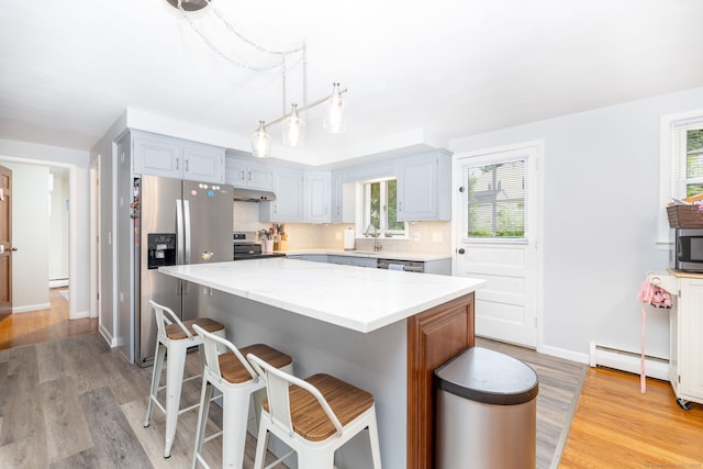 47 Dogwood Ln, Meriden, CT 06450 - kitchen featuring appliances with stainless steel finishes, under cabinet range hood, light wood-style flooring, and a kitchen island