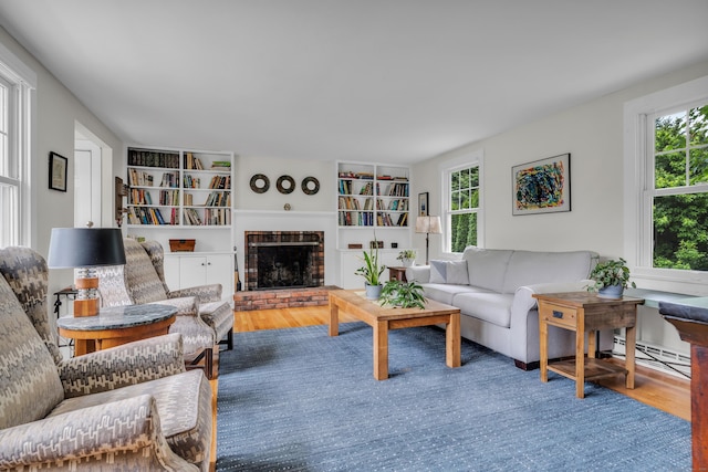 45 Graves Ave, Guilford, CT 06437 - living area featuring a baseboard radiator, wood finished floors, built in shelves, and a brick fireplace