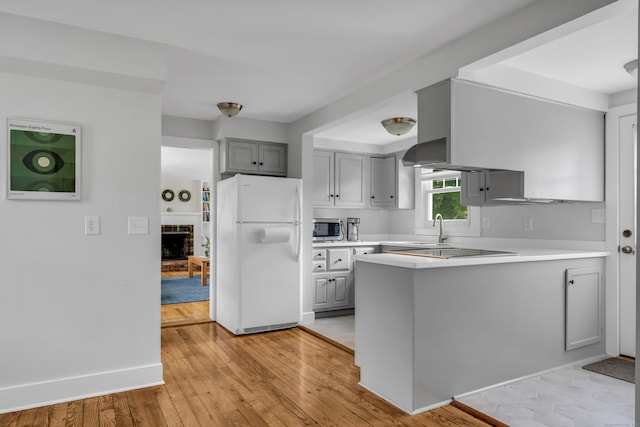 45 Graves Ave, Guilford, CT 06437 - kitchen featuring freestanding refrigerator, stainless steel microwave, gray cabinets, a peninsula, and light countertops