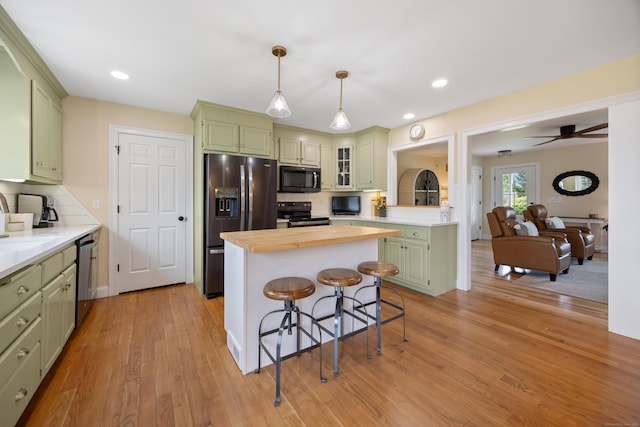 40 Briggs Rd, Lebanon, CT 06249 - kitchen with black appliances, green cabinets, a breakfast bar area, light wood finished floors, and recessed lighting