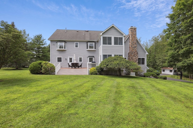 25 Encampment Pl, Ridgefield, CT 06877 - back of property featuring a chimney, a lawn, a wooden deck, and roof with shingles