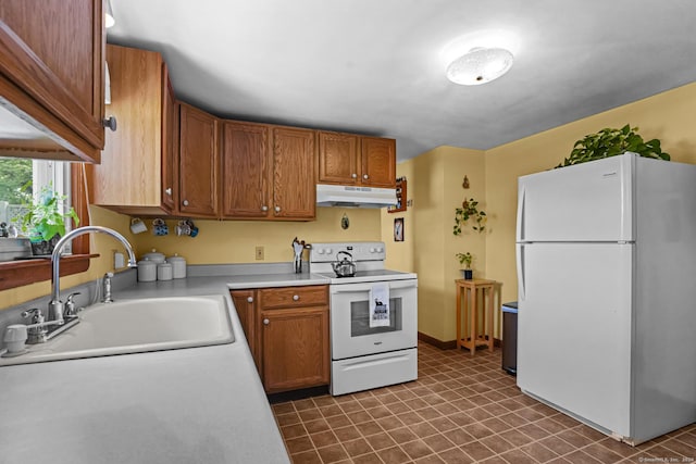 53 Cleveland St, Putnam, CT 06260 - kitchen featuring white appliances, under cabinet range hood, light countertops, dark flooring, and brown cabinetry