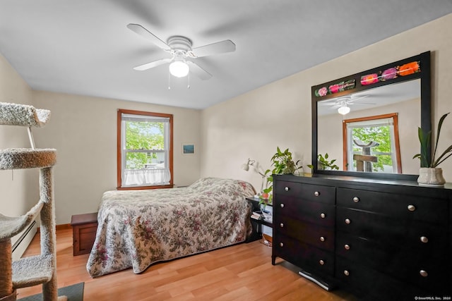 53 Cleveland St, Putnam, CT 06260 - bedroom featuring multiple windows, light wood-style floors, ceiling fan, and a baseboard heating unit