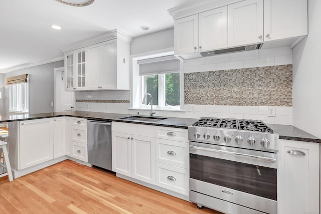 39 Clover Dr, Wilton, CT 06897 - kitchen with stainless steel appliances, a peninsula, white cabinets, backsplash, and ornamental molding