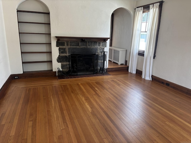 60 Ardmore St, Hamden, CT 06517 - unfurnished living room featuring wood finished floors, a stone fireplace, radiator heating unit, and arched walkways