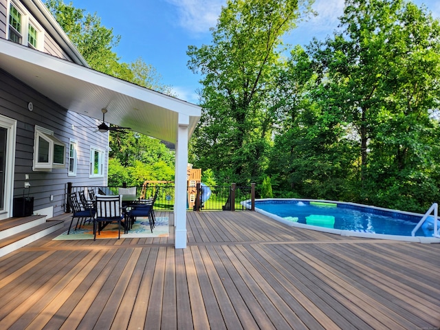 3 Old Woods Rd, Brookfield, CT 06804 - deck with outdoor dining area, a ceiling fan, an outdoor pool, and view of wooded area