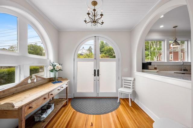 5 S Main St, Essex, CT 06426 - entryway featuring light wood-type flooring, a chandelier, ornamental molding, arched walkways, and french doors
