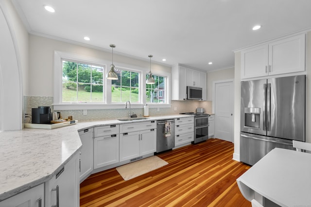 5 S Main St, Essex, CT 06426 - kitchen featuring appliances with stainless steel finishes, crown molding, white cabinetry, decorative backsplash, and decorative light fixtures