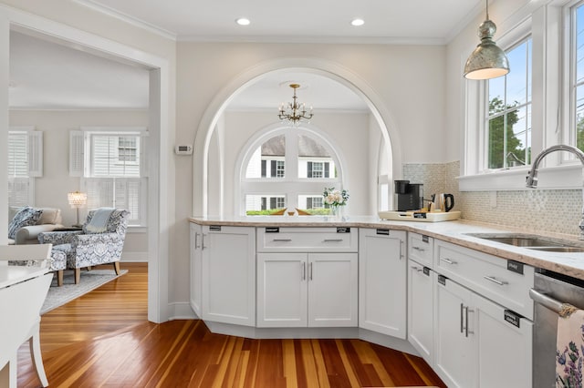 5 S Main St, Essex, CT 06426 - kitchen with light wood-type flooring, stainless steel dishwasher, light stone counters, decorative light fixtures, and white cabinets