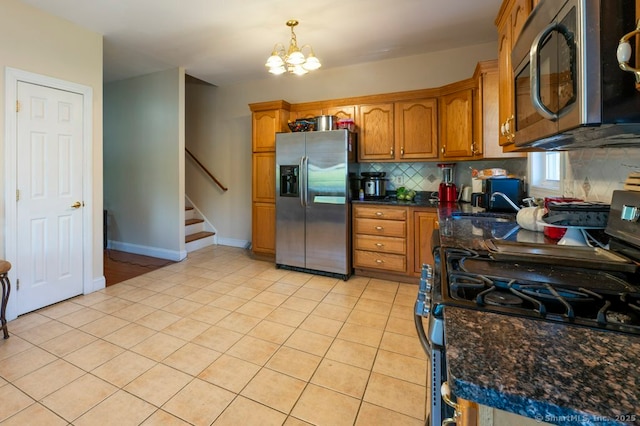 82 Summer St Unit A, Southington, CT 06489 - kitchen featuring appliances with stainless steel finishes, decorative backsplash, light tile patterned flooring, brown cabinetry, and a chandelier