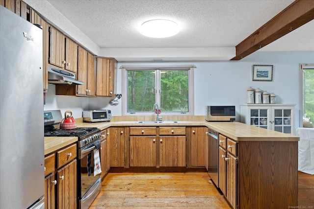 853 Pole Bridge Rd, Woodstock, CT 06281 - kitchen featuring stainless steel appliances, a peninsula, under cabinet range hood, a textured ceiling, and light wood-style floors
