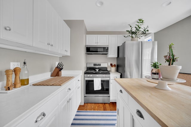 12 Scott St, West Haven, CT 06516 - kitchen with appliances with stainless steel finishes, white cabinets, wooden counters, recessed lighting, and light wood-style floors