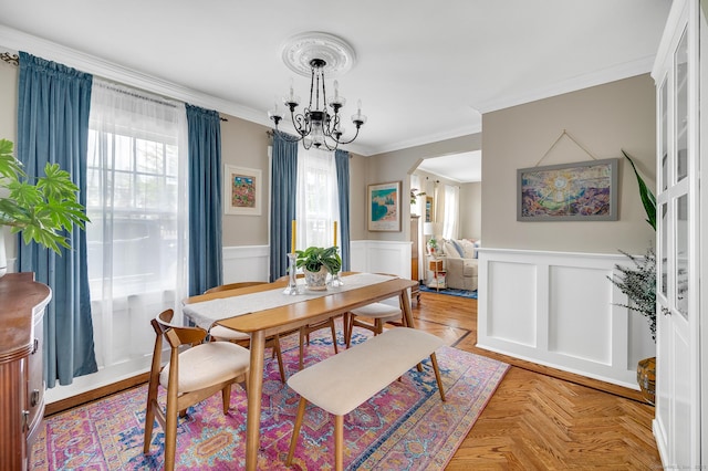 12 Scott St, West Haven, CT 06516 - dining space featuring a chandelier, crown molding, arched walkways, a wainscoted wall, and a decorative wall