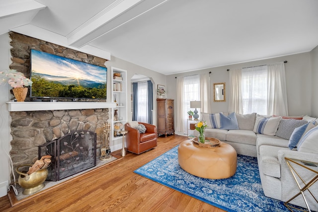 12 Scott St, West Haven, CT 06516 - living area featuring wood finished floors, a stone fireplace, arched walkways, built in features, and beam ceiling