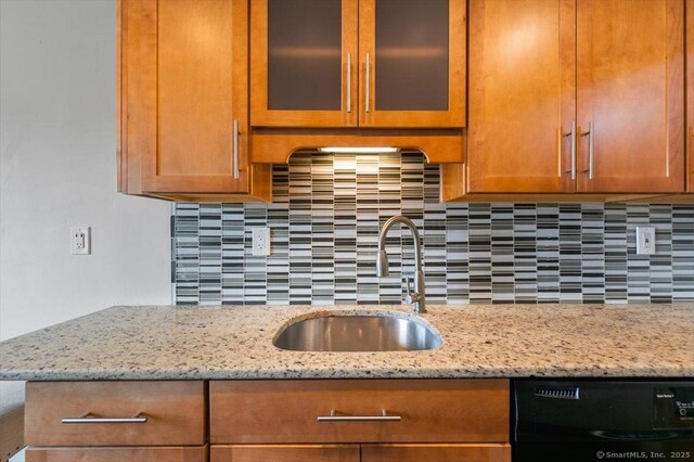 153 Marconi Ave Unit 153, Bridgeport, CT 06606 - kitchen with dishwasher, tasteful backsplash, light stone counters, glass insert cabinets, and brown cabinets