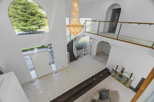 45 Brookview Ct, Groton, CT 06340 - entryway featuring a chandelier, stairway, arched walkways, and a high ceiling
