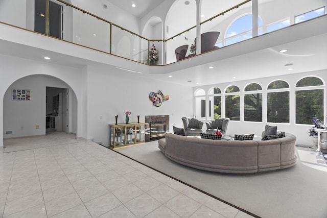 45 Brookview Ct, Groton, CT 06340 - tiled living area with a towering ceiling, recessed lighting, arched walkways, plenty of natural light, and a fireplace
